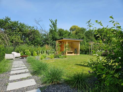 ミクロフにあるDům na jihu Mikulov s finskou saunouの小さなキャビンを背景に広がる庭園