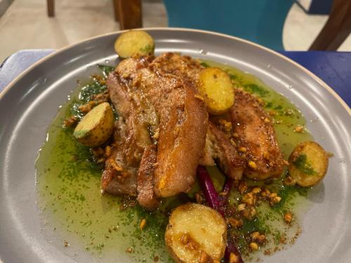 a plate of food with meat and potatoes on a table at Lighthouse View Boutique Hotel in Boracay