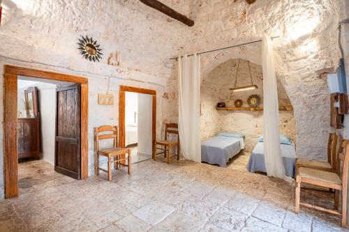 - une chambre avec un lit, une table et des chaises dans l'établissement Trullo Nonno Vittorio, à Latiano