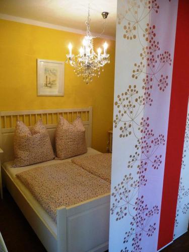 a bedroom with a bed with a chandelier at Ferienwohnungen im Womoland auf No in Nordstrand