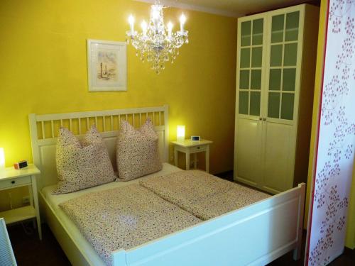 a bedroom with a bed with a chandelier at Ferienwohnungen im Womoland auf No in Nordstrand