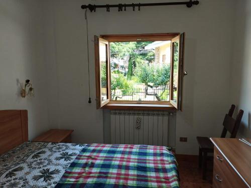 sypialnia z łóżkiem i oknem w obiekcie Mimosa w mieście Tagliacozzo