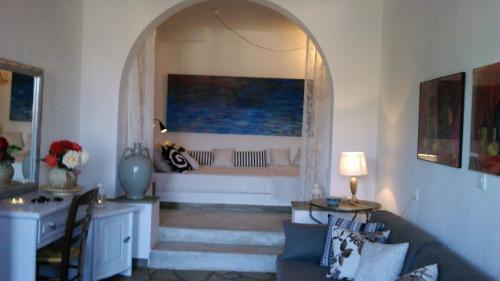 a living room with a couch and an archway at Aperanto Galazio in Skopelos Town