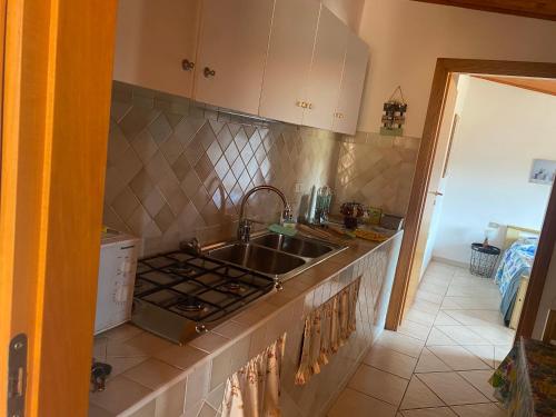 uma cozinha com um lavatório e um fogão em Casa Giola em Solanas