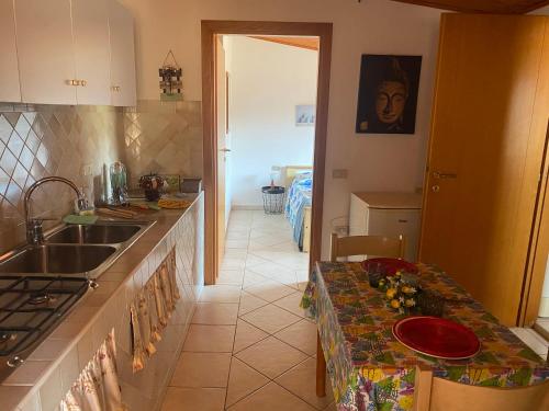 a kitchen with a sink and a counter with a table at Casa Giola in Solanas