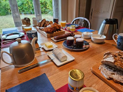 - une table en bois avec des aliments pour le petit-déjeuner et du café dans l'établissement Guest House Le Clos Pasquier, à Blois