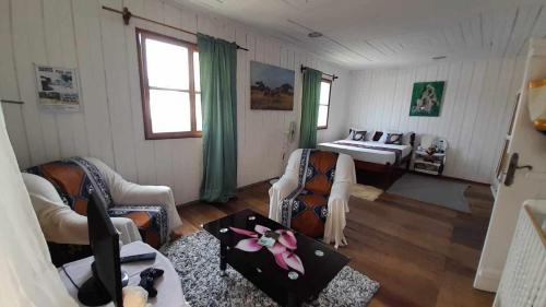 a living room with two chairs and a bed at Hostel Sao Gabriel in São Tomé