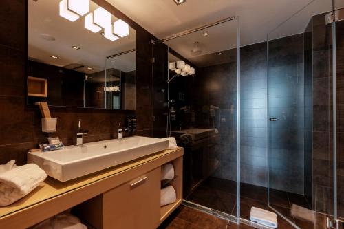 a bathroom with a sink and a glass shower at Eurostars Queen of Montenegro in Budva