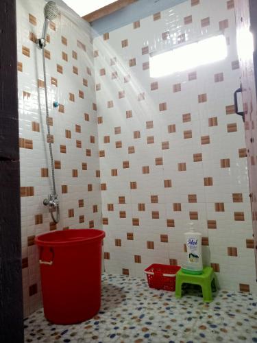 a bathroom with a shower and a red trash can at Tonle Mekong Homestay in Krong Kracheh