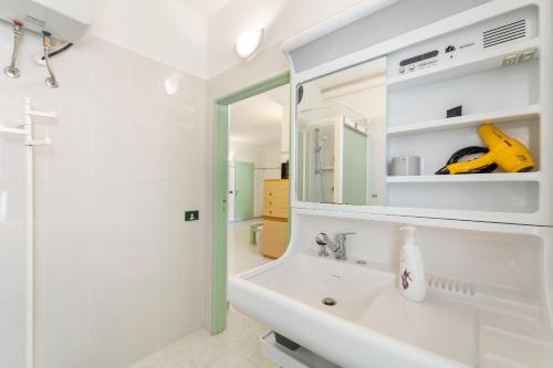 uma casa de banho branca com um lavatório e um espelho em Anna's House em Arbus