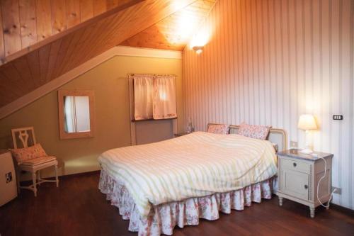 een slaapkamer met een groot bed op zolder bij Villa Di Lambda in Cellarengo