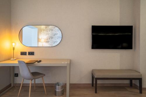 a room with a desk and a mirror and a chair at La Laguna Gran Hotel in La Laguna