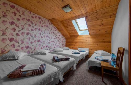 a bedroom with two beds and a wall with flowers at Saules sēta in Lazdenieki