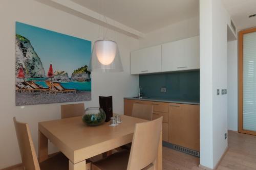 a dining room with a table and a kitchen at Eurostars Queen of Montenegro in Budva