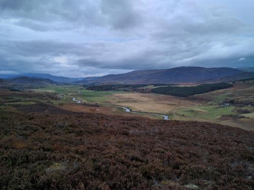 an aerial view of a river in a field at Cluny Mains in Newtonmore