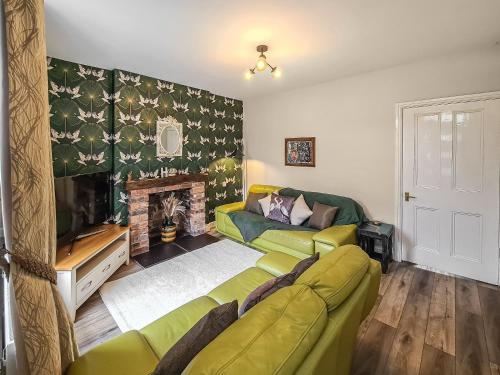 uma sala de estar com um sofá e uma lareira em Orchard House em Langrigg