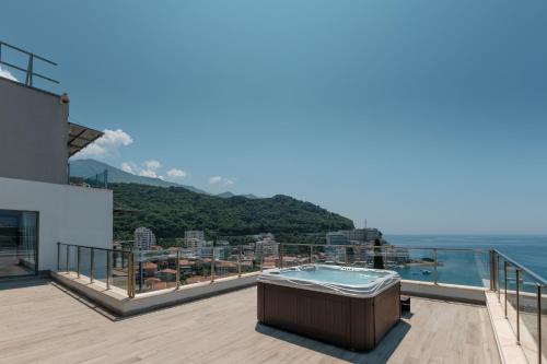 a hot tub on the balcony of a house with the ocean at Eurostars Queen of Montenegro in Budva