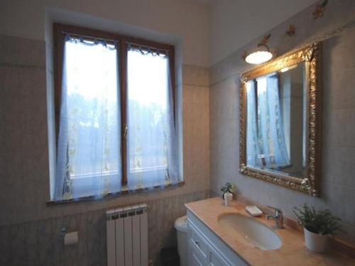 ein Bad mit einem Waschbecken und einem Spiegel in der Unterkunft Il Boschetto in Le Grazie