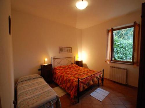Schlafzimmer mit einem Bett und einem Fenster in der Unterkunft Il Boschetto in Le Grazie