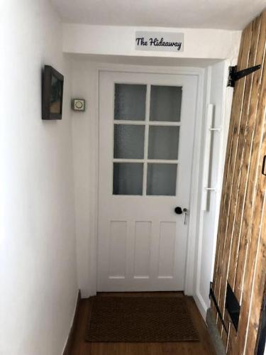 a white door with a sign that reads the fellowship at Lyme Clifftop Hideaway in Lyme Regis