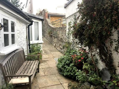 a bench sitting in a garden next to a building at Lyme Clifftop Hideaway in Lyme Regis