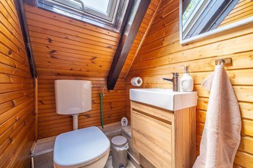 a wooden bathroom with a toilet and a sink at Kuća za odmor Šum slapa in Karlovac