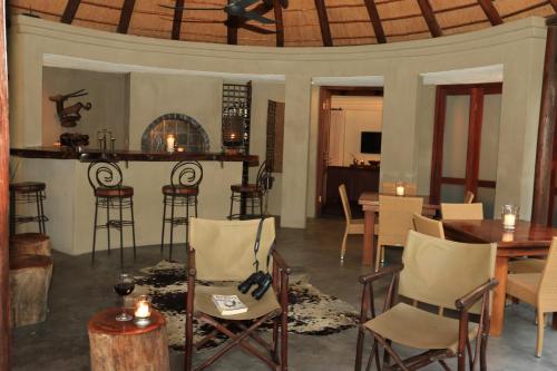 a living room with chairs and a table and a bar at La Lechere Guest House in Phalaborwa