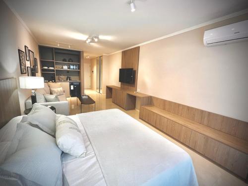 ブエノスアイレスにあるLuxury Apartments in Deco Recoleta by Apartments Barilocheのベッドルーム(白いベッド1台付)、リビングルームが備わります。
