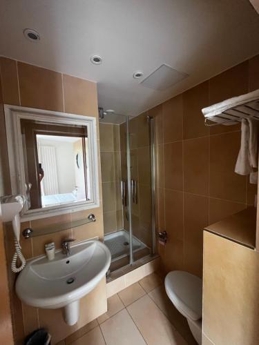 y baño con lavabo y ducha. en Hôtel Tingis en París
