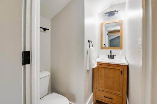 a bathroom with a sink and a toilet and a mirror at Bell Street by the Falls in Chagrin Falls