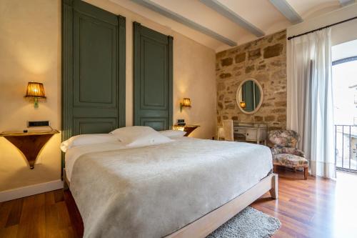Un dormitorio con una cama grande y una ventana grande. en YIT La Casona del Arco, en Baeza