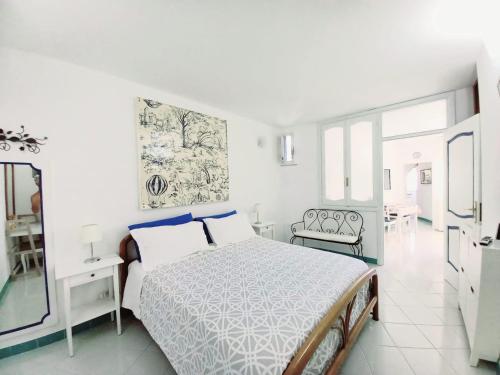 a white bedroom with a bed and a dining room at Blue Line House Positano in Positano