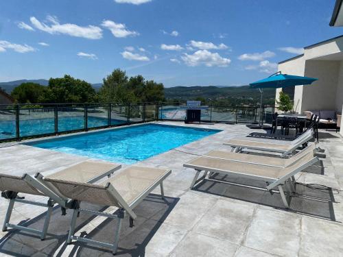 une piscine avec deux chaises et une table dans l'établissement Villa avec vue panoramique sur les Cévennes, à Saint Julien Les Rosiers