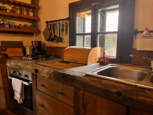 a kitchen counter with a sink and a window at The Village Pension in Breb