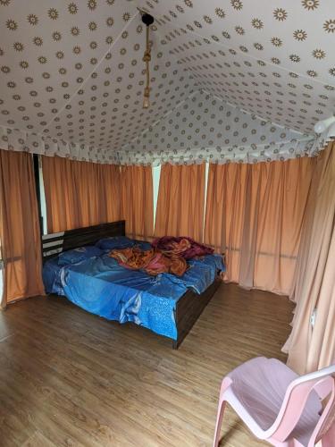 ein Schlafzimmer mit einem Bett in einem Zimmer mit Vorhängen in der Unterkunft Panshet Camping in Welhe
