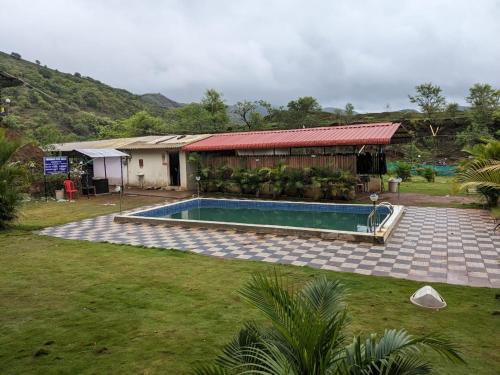a swimming pool in a yard next to a building at Panshet Camping in Welhe