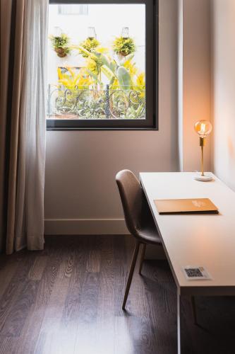 a table and a chair in a room with a window at La Laguna Gran Hotel in La Laguna