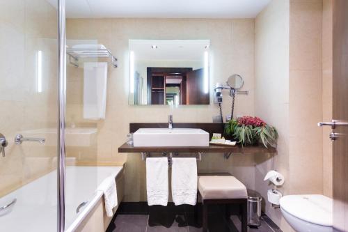 a bathroom with a sink and a toilet and a mirror at La Laguna Gran Hotel in La Laguna