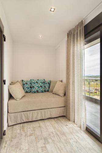 a couch in a living room with a window at THEA Luxury Apartments in Vourvourou