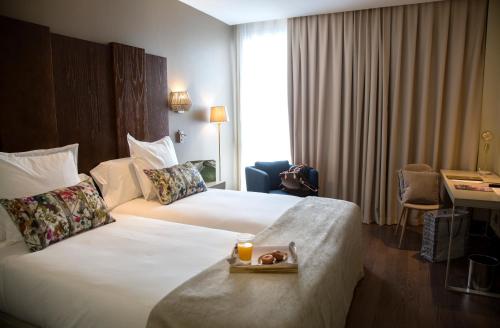 a hotel room with two beds and a tray of food at La Laguna Gran Hotel in La Laguna