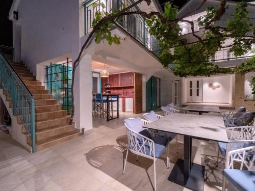 a dining room with a table and chairs and stairs at Vila Gina in Bar