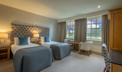 a hotel room with two beds and a desk at Slieve Russell Hotel in Ballyconnell