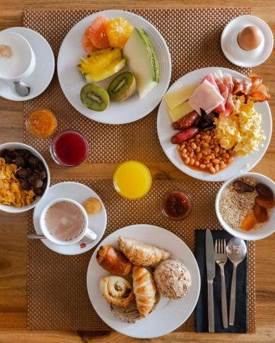 a table with plates of breakfast foods on it at 9Hotel Mercy in Lisbon