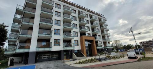 un immeuble d'appartements avec une voiture garée devant lui dans l'établissement Bel Mare Aqua, à Międzyzdroje