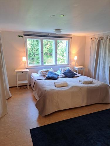 1 dormitorio grande con 2 camas y 2 ventanas en Norrby Gård - Sjövik, en Raseborg