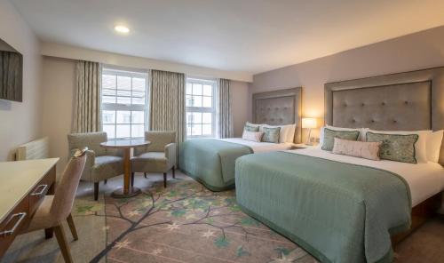 a hotel room with two beds and a table and chairs at Slieve Russell Hotel in Ballyconnell