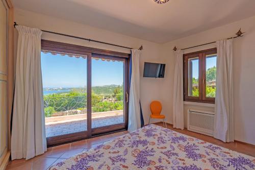a bedroom with a bed and a large window at Villetta Bomboniera in Arzachena