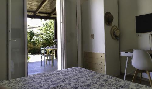 een slaapkamer met een bed en een deur naar een patio bij B&B Il Carlino in Villaggio Azzurro