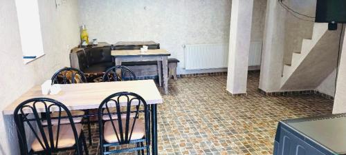 Habitación con sillas, mesa y escaleras. en GERGETI Arsenas Guest House, en Kazbegi