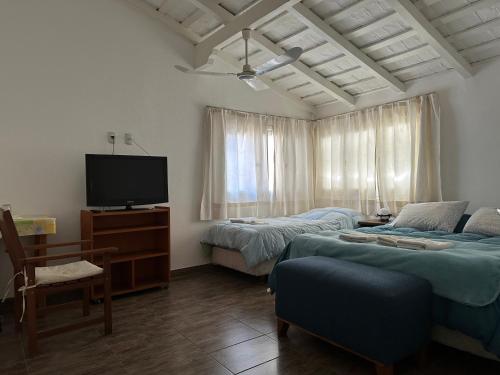 a bedroom with two beds and a flat screen tv at ApartHosteriaPlaza in La Cumbre